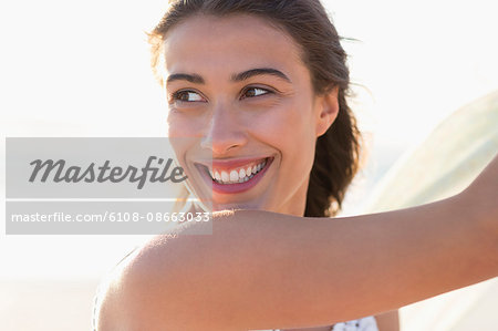 Attractive young woman smiling on the beach