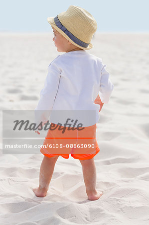 Rear view of a baby boy standing on the beach