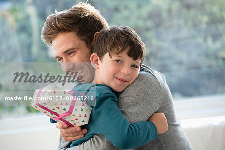 Loving father and son hugging with birthday gift