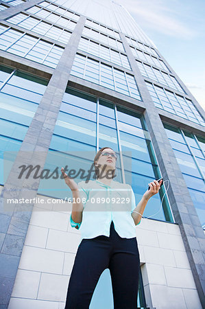 Businesswoman with stress talking on the phone in front of a building