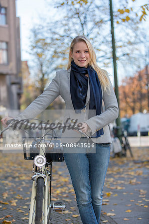 Pretty blond woman with bicycle in city center