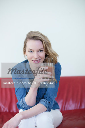 Woman enjoying a drink on the couch