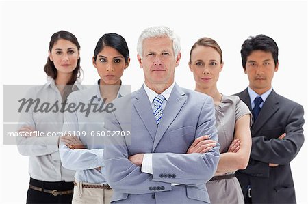 Close-up of a multicultural business team behind their boss against white background