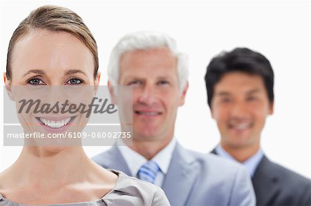 Close-up of smiling business people in a single line with focus on the woman against white background