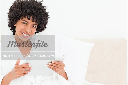 Smiling frizzy haired woman in a robe with a touchpad
