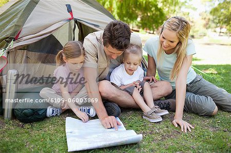 A family in the park look at the map together to see where they are camping