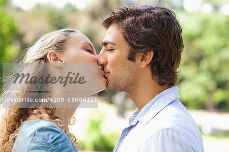 Side view of young couple kissing in the park