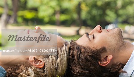 Side view of a young couple relaxing on the lawn