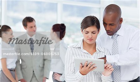 Young salesman showing his colleague how to use a tablet