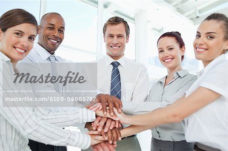 Smiling young businessteam doing teamwork gesture