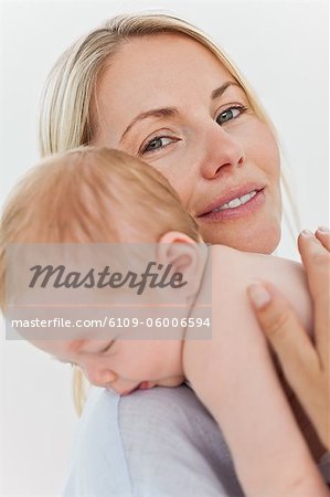 Smiling young mother holding her baby close