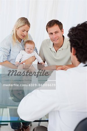 Male doctor talking to young family