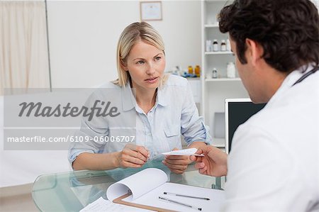 Worried looking woman getting prescription from her doctor