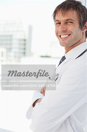 Side view of a doctor smiling while standing upright and looking at the camera