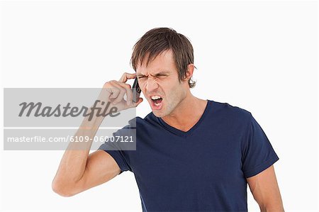 Furious man shouting while calling with his mobile phone Furious man shouting while calling with his mobile phone