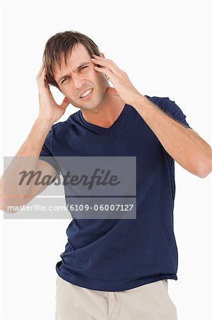 Man looking at the camera while showing a headache against a white background