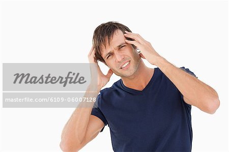 Man tilting his head while showing a headache by placing his hands on his temples