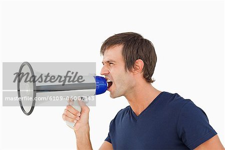 Furious man shouting through a megaphone against a white background