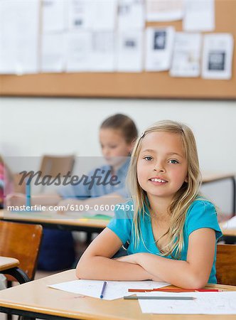 Elementary Student Sitting At Her Desk With Arms Folded Stock