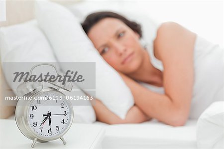 Alarm clock with a woman who just wakes up