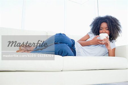 Portrait of a fuzzy hair woman drinking a coffee