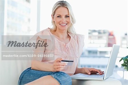 Portrait of a blonde buying online with a laptop