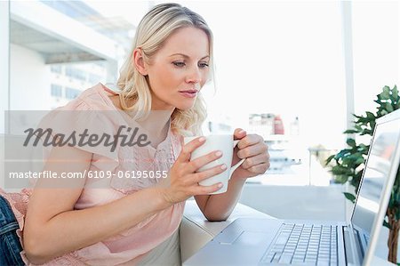 Blonde on a laptop with a tea Blonde on a laptop with a tea