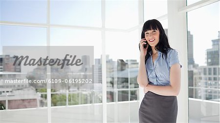 Young woman smiling while talking on the phone in a well-lit room