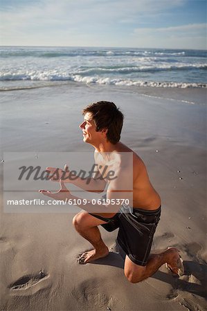 Young attractive man playing on the beach