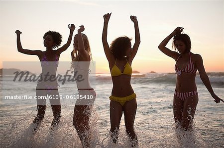 Young women showing their happiness at sunset