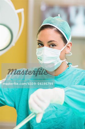 Female surgeon performing while looking at camera