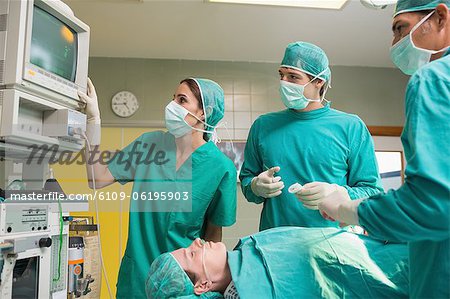 Nurse and surgeons looking at the monitor