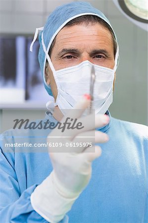 Male surgeon holding a scalpel in his hand