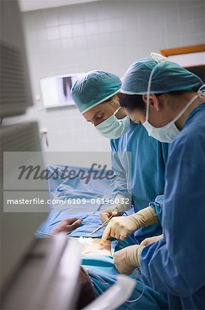 Side view of a team of surgeons doing an operation