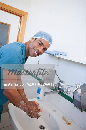 Happy male surgeon washing his hands