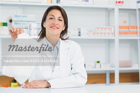 Smiling pharmacist woman holding a prescription