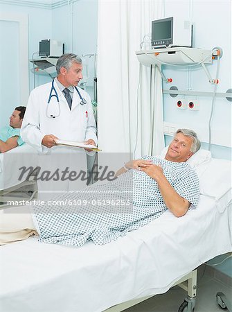 Doctor talking to a patient in a bed ward