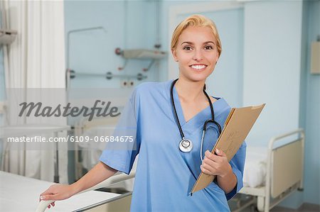 Nurse smiling while holding a folder
