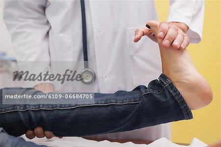 Doctor auscultating a patient ankle