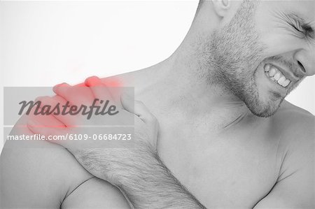 Man wincing in pain at sore shoulder