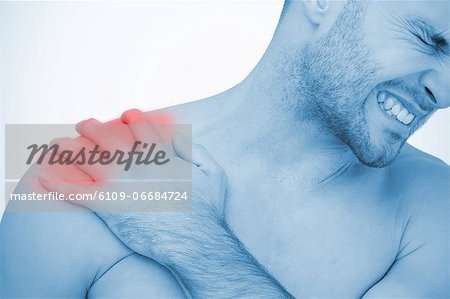 Man wincing in pain at shoulder pain