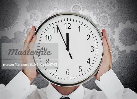 Businessman hiding his face with white clock