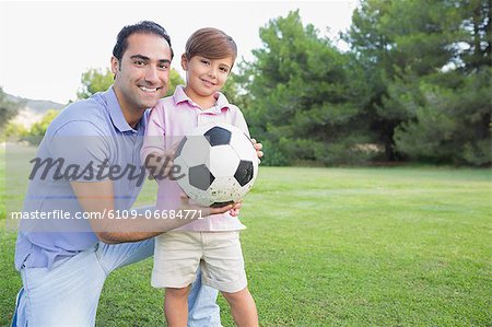 Portrait of father and son with a football