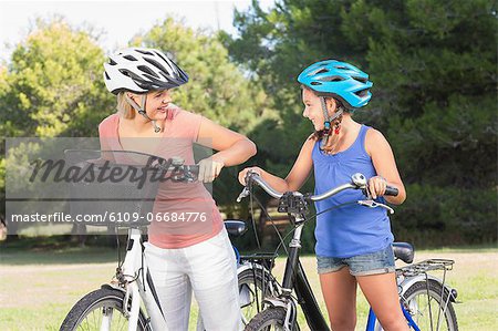 Mother and daughter chatting and standing with bikes