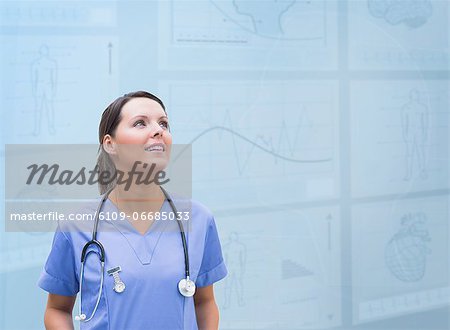 Nurse looking up against blue digital background