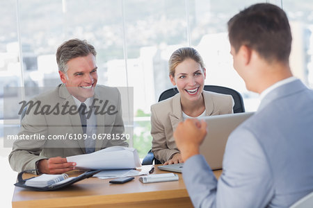 Smiling business people laughing with applicant