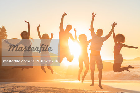 Young people jumping in front of the sunset