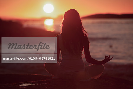 Premium Photo  A woman practicing yoga on the beach at sunset