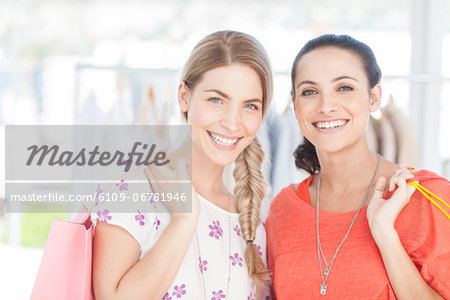 Delighted friends holding shopping bags