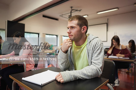 Smiling male student listening intently in class at the university